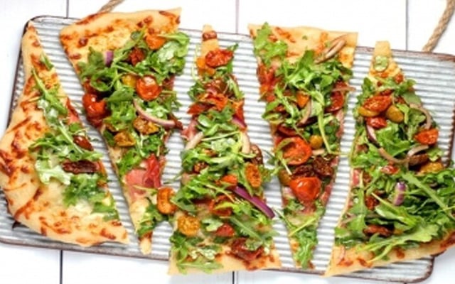 Sydney shop gives out pizza to people lining up for Covid tests